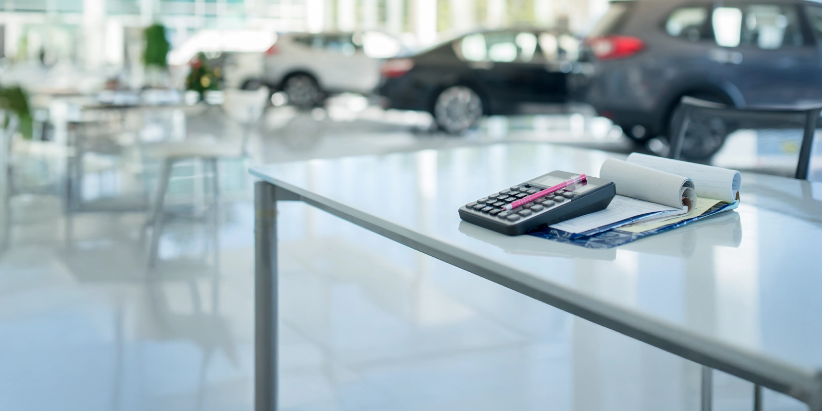 Calculatrice et paperasse sur le bureau du concessionnaire